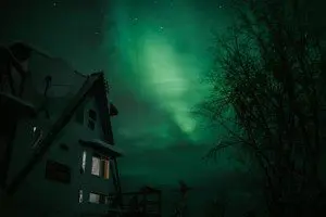 Treehouse-style rental in Fairbanks, Alaska illuminated by northern lights