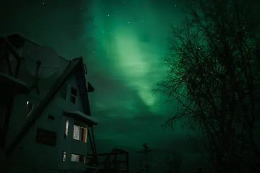 Treehouse-style rental in Fairbanks, Alaska illuminated by northern lights