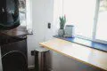 Sunny laundry area with potted plant and trash bin in Fairbanks treehouse rental