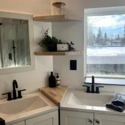 Glass-enclosed shower with marble-style tile in a modern Fairbanks treehouse bathroom
