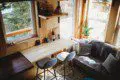 Modern rustic treehouse interior with bar seating, cozy couch, and natural light in Fairbanks, Alaska
