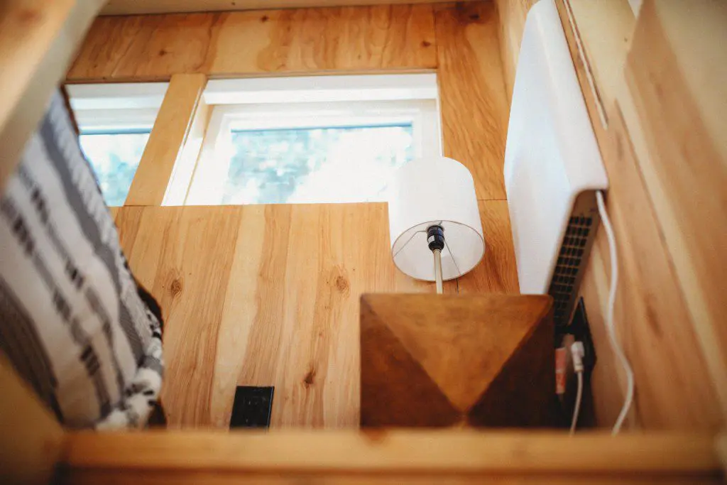 Wood-paneled treehouse interior with modern lamp and natural light in Fairbanks Alaska