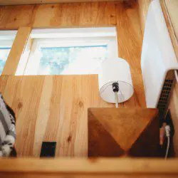 Wood-paneled treehouse interior with modern lamp and natural light in Fairbanks Alaska