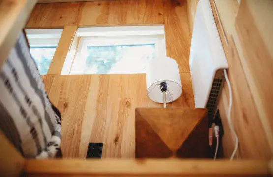 Wood-paneled treehouse interior with modern lamp and natural light in Fairbanks Alaska