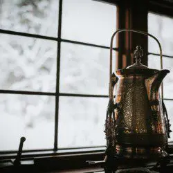 Decorative lantern on windowsill with snowy forest view in a cozy Fairbanks Alaska lodge