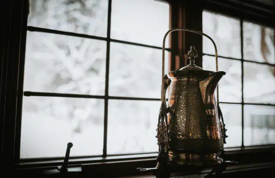 Decorative lantern on windowsill with snowy forest view in a cozy Fairbanks Alaska lodge