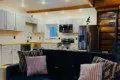 Stylish kitchen with white cabinets and navy couch in a rustic Fairbanks Alaska treehouse rental