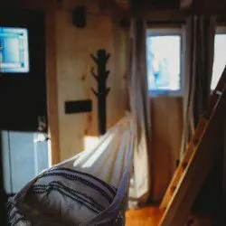 Interior view of treehouse rental in Fairbanks Alaska with wooden walls, TV, and yellow couch