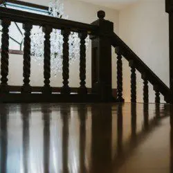 Wooden staircase with chandelier reflection on polished floor in a Fairbanks Alaska lodge or rental