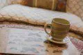 Close-up of a ceramic coffee cup on a butterfly print tray with patterned pillows in the background, Fairbanks Alaska