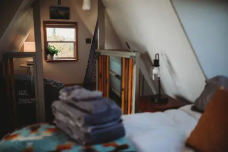 Soft towels on bed in a loft bedroom inside a Fairbanks Alaska treehouse rental