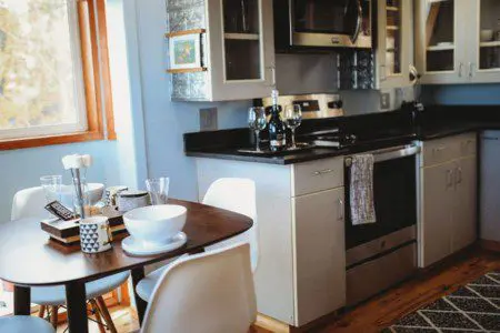 Kitchen with stainless appliances and dining table set for two in a Fairbanks Alaska treehouse