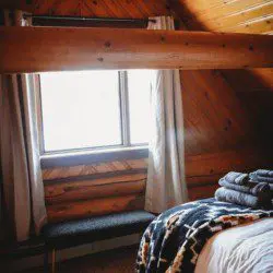 Close-up of champagne and glasses on bedside table in a cozy Fairbanks Alaska treehouse