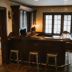 Wooden bar with metal stools and large windows in a rustic Fairbanks Alaska lodge