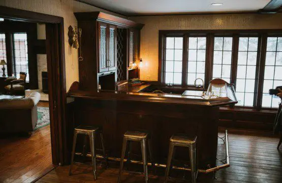 Wooden bar with metal stools and large windows in a rustic Fairbanks Alaska lodge