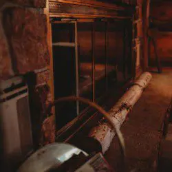 Warm, dimly lit corner with a stone and glass fireplace and rustic wood accents in a Fairbanks Alaska lodge