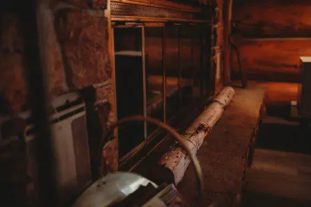 Warm, dimly lit corner with a stone and glass fireplace and rustic wood accents in a Fairbanks Alaska lodge