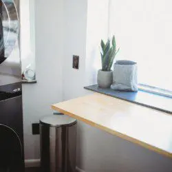 Black stacked washer and dryer in compact laundry nook of Fairbanks treehouse rental