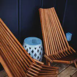  Two slatted wooden lounge chairs and a ceramic side table on a Fairbanks Alaska treehouse deck