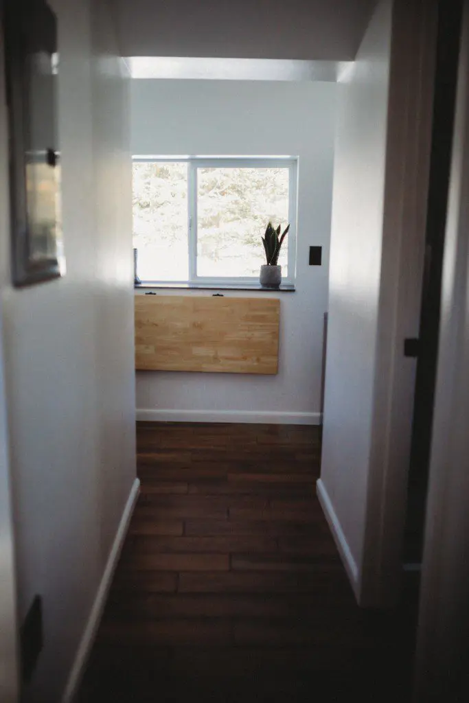 Narrow hallway with wood flooring and window view in a Fairbanks Alaska treehouse rental
