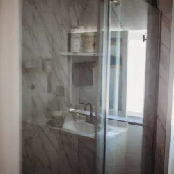 Compact modern bathroom with dual sinks, wood shelves, and black fixtures in Fairbanks Alaska rental