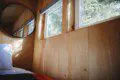 Wooden interior wall with windows and mirror inside a rustic Fairbanks Alaska treehouse