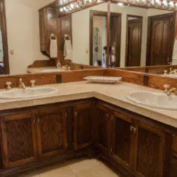 Cozy bathroom with wooden vanity, wall cross decor, and toilet in a Fairbanks Alaska lodge or treehouse rental