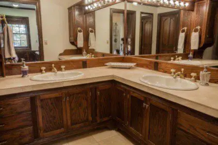 Cozy bathroom with wooden vanity, wall cross decor, and toilet in a Fairbanks Alaska lodge or treehouse rental