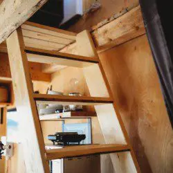 View looking down wooden stairs from a loft inside a Fairbanks Alaska treehouse rental