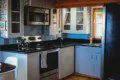 Modern kitchen with stainless steel appliances and blue cabinets in a Fairbanks Alaska treehouse