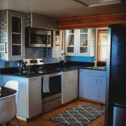 Modern kitchen with stainless steel appliances and blue cabinets in a Fairbanks Alaska treehouse