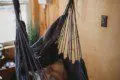 Indoor hanging hammock chair with pillow in a wood-paneled room of a Fairbanks Alaska treehouse rental