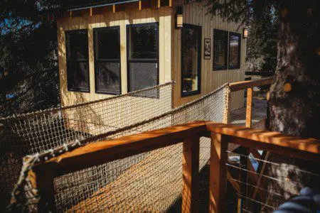 Exterior view of a wooden treehouse with railing and large windows in Fairbanks Alaska