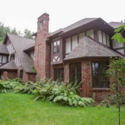 Brick and timber Tudor-style lodge surrounded by greenery in Fairbanks Alaska