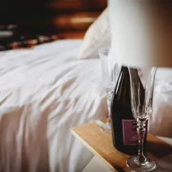 Close-up of champagne and glasses on bedside table in a cozy Fairbanks Alaska treehouse