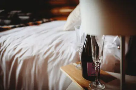Close-up of champagne and glasses on bedside table in a cozy Fairbanks Alaska treehouse