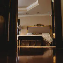 Warm, elegant bedroom with a classic bed frame viewed from doorway in a Fairbanks Alaska adventure lodge