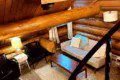 Overhead view of cozy log cabin-style living room with sofa and chairs in Fairbanks Alaska treehouse