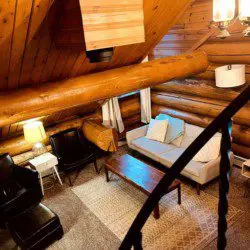 Overhead view of cozy log cabin-style living room with sofa and chairs in Fairbanks Alaska treehouse