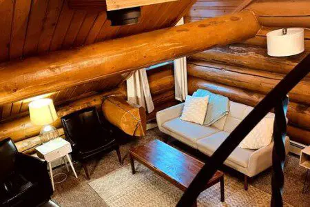 Overhead view of cozy log cabin-style living room with sofa and chairs in Fairbanks Alaska treehouse