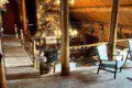 Wooden lodge interior with loft seating, stone fireplace, and taxidermy decor in Fairbanks, Alaska