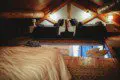 Wood-beamed loft with twin beds and cozy lighting in a Fairbanks Alaska treehouse rental