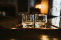Two empty glasses on a wooden bar counter in a warmly lit Fairbanks Alaska lodge