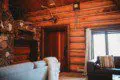 Warm log wall interior with stone fireplace, antlers, and cozy seating in a Fairbanks Alaska lodge