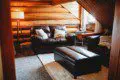 Rustic cabin-style living room with leather furniture in Fairbanks Alaska treehouse rental