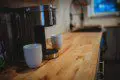 Coffee maker with two white mugs on a wooden counter in a Fairbanks Alaska treehouse kitchen