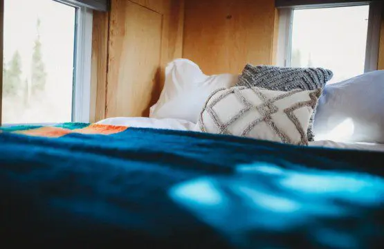 Comfy bed with pillows and soft blanket inside a Fairbanks Alaska treehouse rental