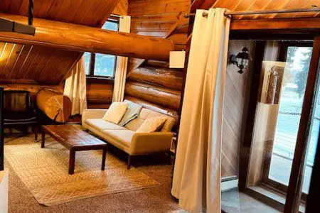Overhead view of cozy log cabin-style living room with sofa and chairs in Fairbanks Alaska treehouse