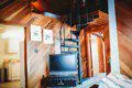 Cozy leather seating and warm wood interior of a Fairbanks treehouse rental with view into a small kitchen