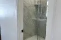 Glass-enclosed shower with marble-style tile in a modern Fairbanks treehouse bathroom